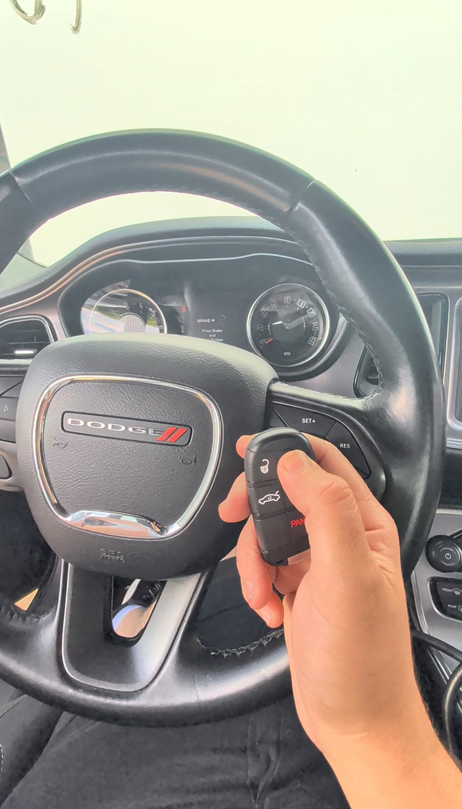 Freshly made and programmed key fob held at the wheel of a running 2023 Dodge Challenger by Turbo Keysmith in the Oklahoma City metro