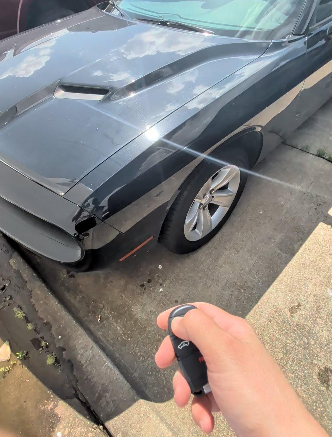 New key fob in hand beside a black 2023 Dodge Challenger, made on-site by Turbo Keysmith in the OKC metro