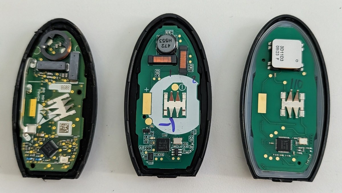 Three Nissan / Infiniti smart key fobs opened up side by side — OEM, quality aftermarket, and a cheap online fob